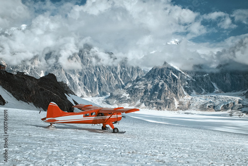 Red plane landing on a glacier in Denali mountains. Winter expedition.