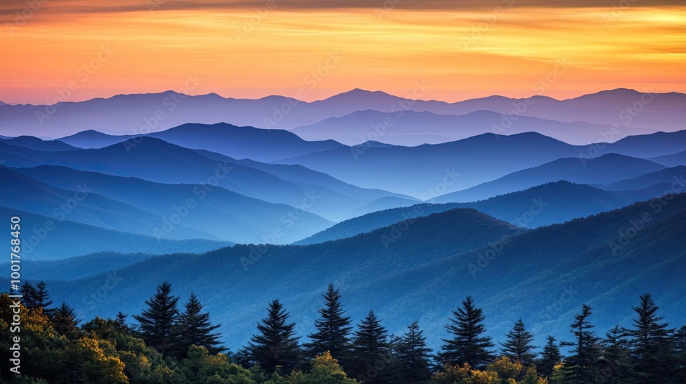 A picturesque sunrise over a vast mountain range with rolling hills and layers of blue hues. A picturesque sunrise over a vast mountain range with rolling hills and layers of blue hues.