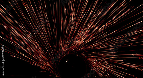 red sparks from the grinder glowing in the dark