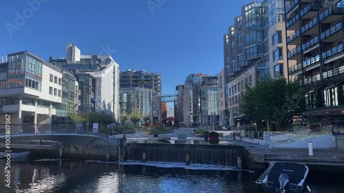 Modern urban environment with skyscrapers and a river under a clear sky, TJuvholmen, Oslo, Norway, Europe photo