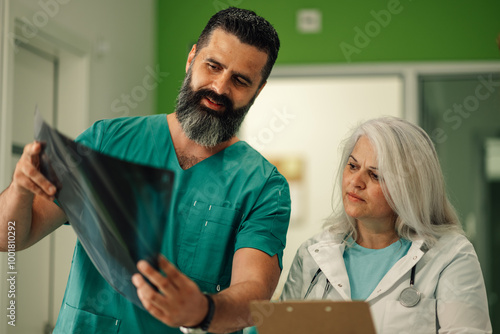 Medical professionals discuss patient's X-ray image in detail.