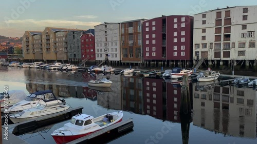 Harbour scene with boats and colourful buildings in the water creating a peaceful evening mood, old warehouses and storehouses, Nidelva, Trondheim city centre, Tröndelag, Norway, Europe