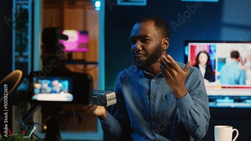 African american internet star doing technology review of wireless portable speaker for online platforms channel. BIPOC influencer presenting music playing device to his fanbase