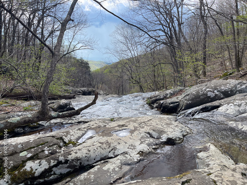 Standing at Upper White Oak Falls, you gaze out over Shenandoah National Park, where the cascading water meets the vast expanse of green forest and rolling hills, creating a breathtaking natural view. photo