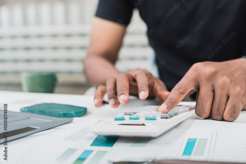 Man use calculators and documents that calculate expenses in the home office Man use calculators and documents that calculate expenses in the home office