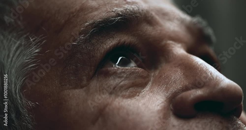 Elderly man close-up eyes gazing UPWARDS at sky. Older 70s person looking up with wrinkled expression in quiet contemplation