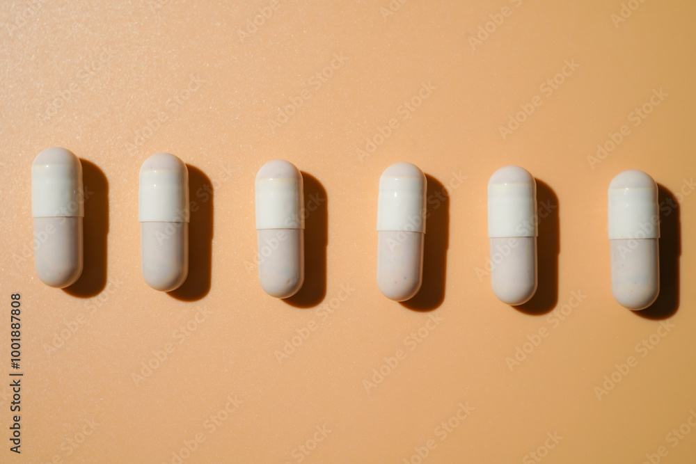 medicine capsules in a line on light beige, Medical and healthcare, dietary supplements and vitamins medicine capsules in a line on light beige, Medical and healthcare, dietary supplements and vitamins