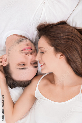 Happy couple spending time together on bed at home, top view