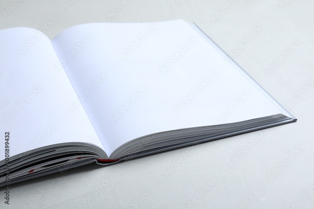 Open book with hard cover on light grey table, closeup Open book with hard cover on light grey table, closeup
