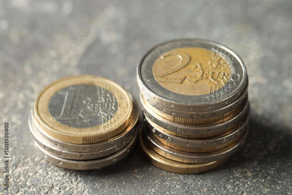 Stacked euro coins on grey table, closeup Stacked euro coins on grey table, closeup