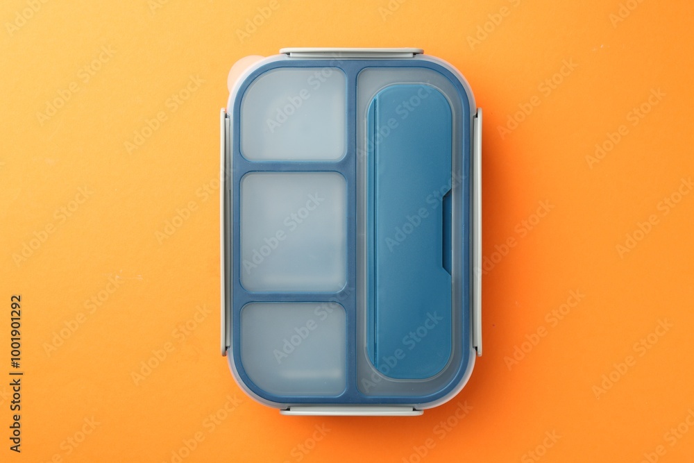 One lunch box on orange background, top view One lunch box on orange background, top view