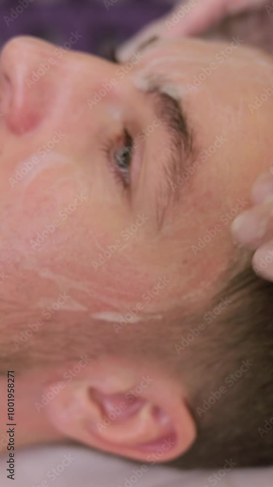 Man enjoying facial treatment at spa, relaxing with eyes closed. Professional massage Man enjoying facial treatment at spa, relaxing with eyes closed. Professional massage