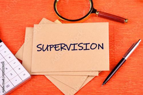 The word supervision. concept of supervision. the action, process, or occupation of supervising. SUPERVISION on postal envelopes on an orange background, top view