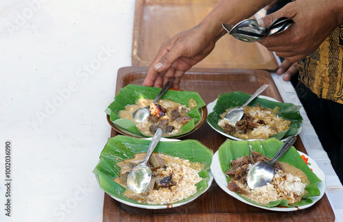 Close up of hands preparing nasi gandul. Nasi gandul is a typical culinary of Pati (coastal area of ​​Central Java, north coast road of Java). photo