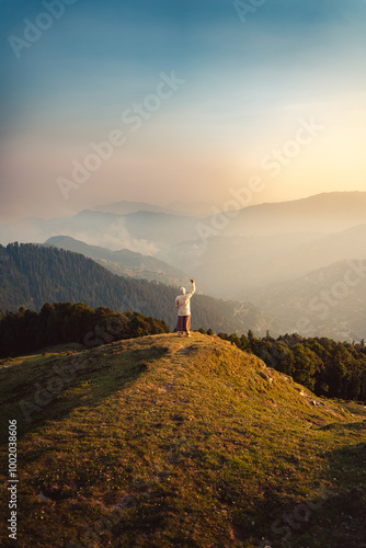 Man tourist stands with arms raised. Beautiful landscape of the Himachal Pradesh India. photo