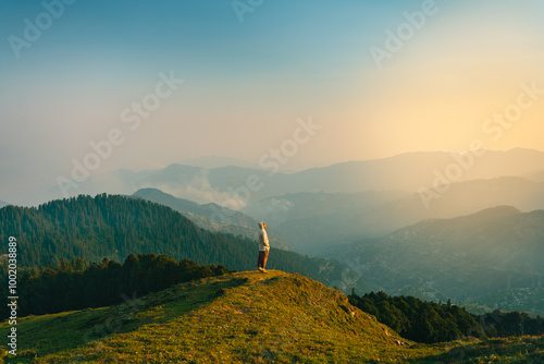 Man on top of a Mountain Cliff with Dramatic Landscape in Background during Sunset or Sunrise, Soja, Himachal Pradesh, India. photo