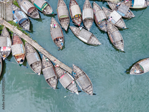 Aerial view of boatmen navigate their vessel across the Shitalakshya River, carrying passengers from Bandar Ghat in Narayanganj, Bangladesh. photo