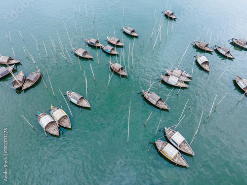 Aerial view of boatmen navigate their vessel across the Shitalakshya River, carrying passengers from Bandar Ghat in Narayanganj, Bangladesh. photo