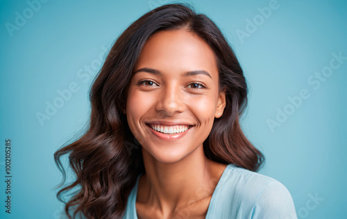 woman smiling at camera on light blue background