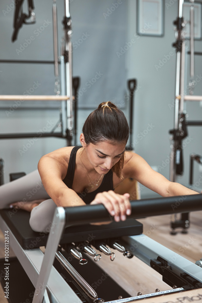 Young woman exercising in a gym on pilates machines. Young woman exercising in a gym on pilates machines.