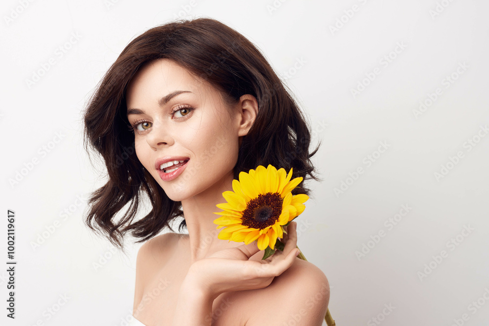 Beautiful young woman holding a sunflower on a white background Beautiful young woman holding a sunflower on a white background