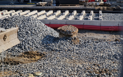 new and precise laying of tracks using leveling devices at the fork in two tram tracks. a layer of gravel above which concrete sleepers are placed. rubber anti-vibration base made of rubber photo