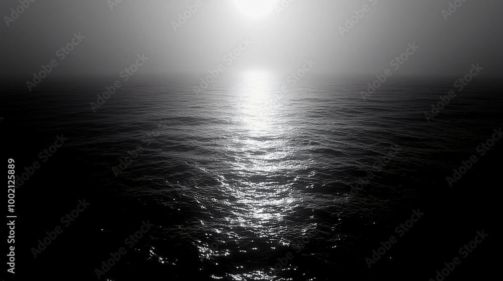 Monochrome seascape with the sun setting over a calm ocean Monochrome seascape with the sun setting over a calm ocean