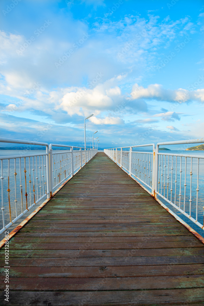 Obraz premium Wooden walking track built on the sea. Wooden bridge by the sea. Walking track with wooden floor and iron railings built in the sea. Quay walking area. Sea of ​​Erdek.