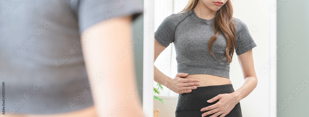 © Pormezz - Body care and weight loss concept, Close-up shot of woman looking at mirror touch her belly and worry about her figure. © Pormezz - Body care and weight loss concept, Close-up shot of woman looking at mirror touch her belly and worry about her figure.