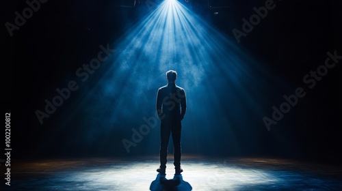 A Silhouette of a Man Standing in a Spotlight on a Stage