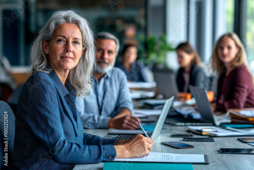 Senior businesswoman in meeting with her team in a modern office