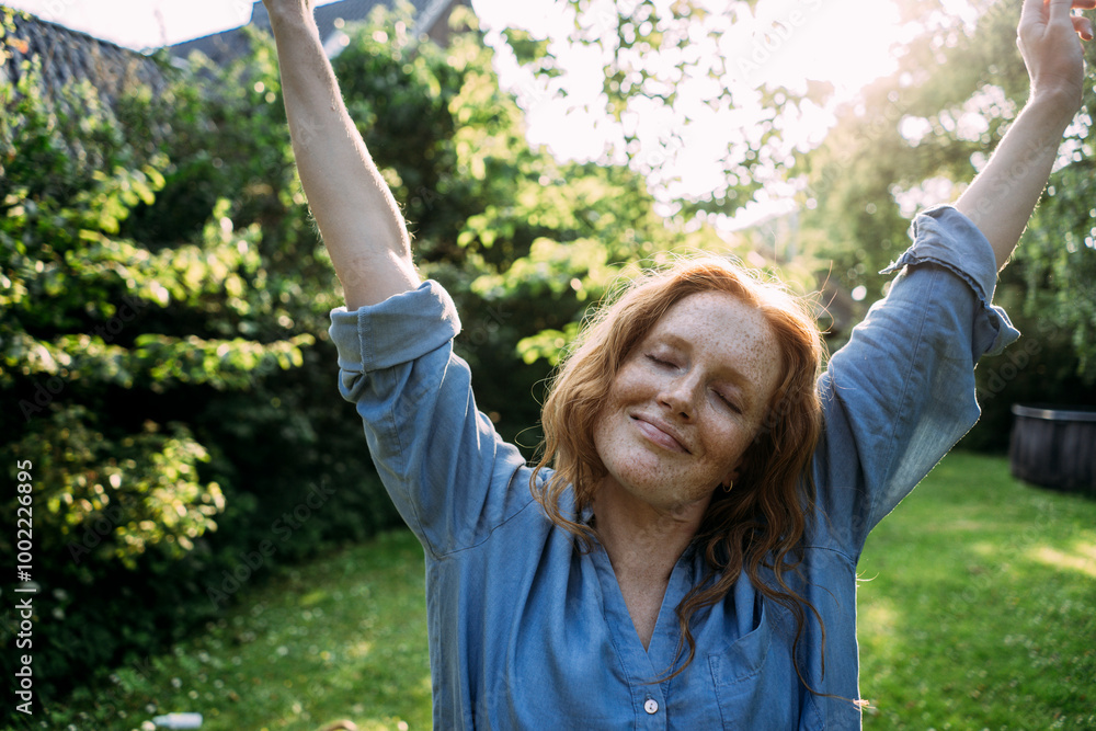 Smiling woman in blue shirt with arms raised Smiling woman in blue shirt with arms raised