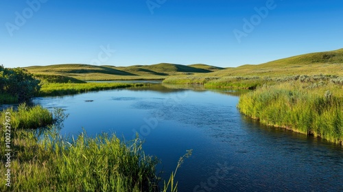 A peaceful nature scene with a clear blue sky, rolling hills, and a calm river.