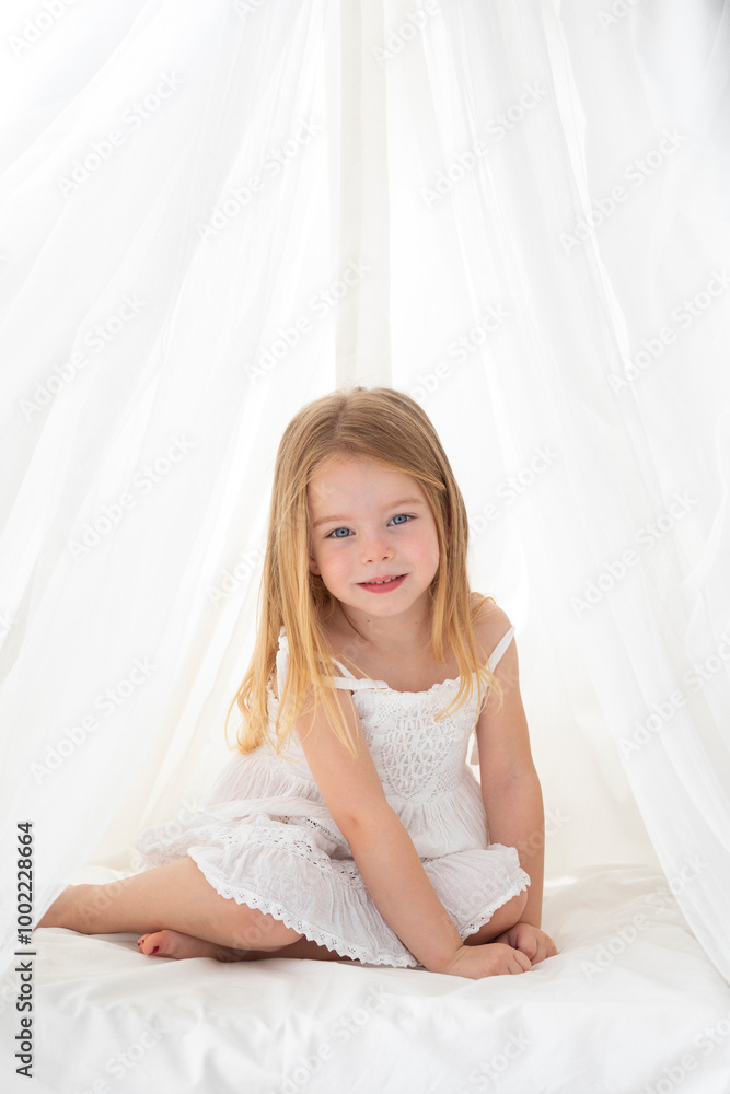 Blond hair girl wearing white dress sitting in teepee Blond hair girl wearing white dress sitting in teepee