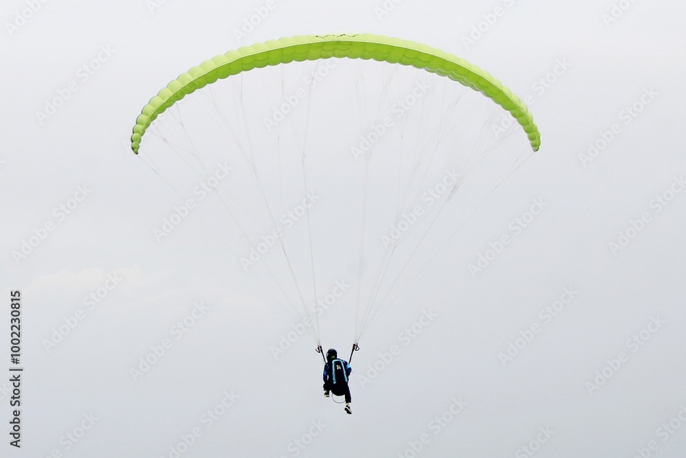paragliding pilot flying in the blue sky with white clouds paragliding pilot flying in the blue sky with white clouds