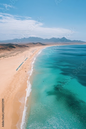 Sunny beach with golden sand and clear turquoise water under a blue sky