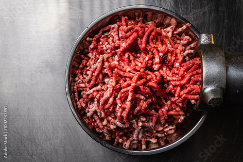 Process of fresh meat grinding in the kitchen with modern electric grinder, top down