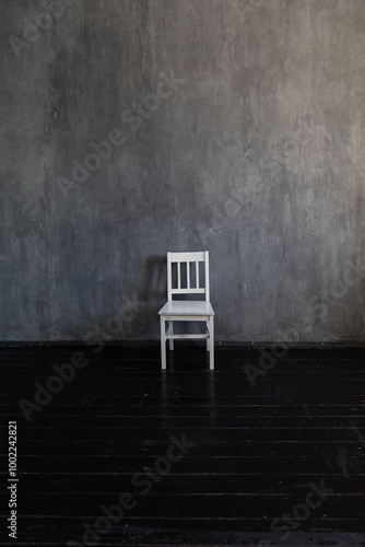 One white chair in the interior of an empty gray room