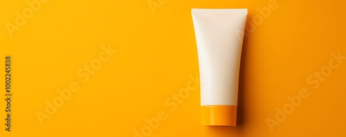 Cosmetic tube on vibrant yellow background, minimalistic design.