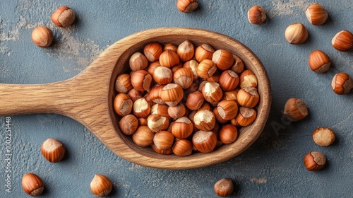Hazelnuts in a wooden spoon on a dark stone surface