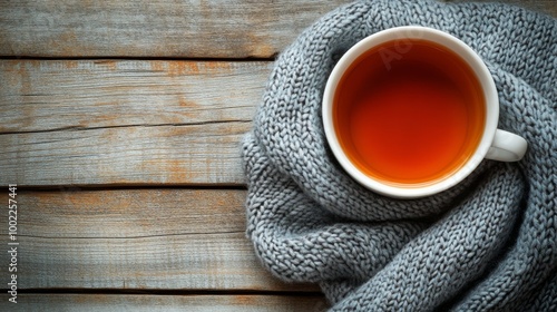 Warm cup of tea on a cozy knit blanket in a rustic setting