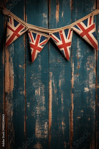 Decorative Union Jack bunting hanging on a rustic blue wooden wall for a fest...