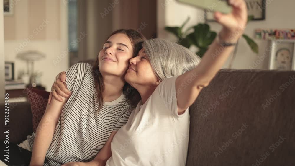 Mother and Daughter Taking a Selfie Together on the Couch Mother and Daughter Taking a Selfie Together on the Couch