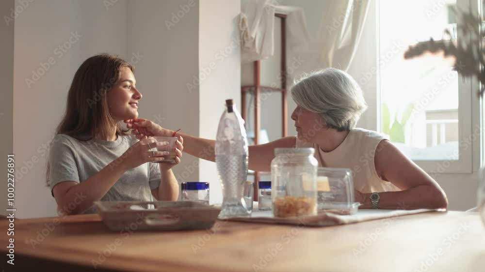 Mother and daughter having a conversation over breakfast Mother and daughter having a conversation over breakfast