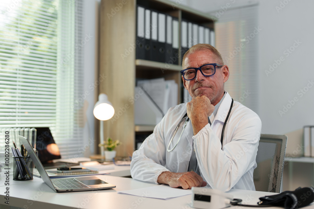 Male doctor, scientist, specialist working with laptop, making work calls, studying data, biological research at desk in office in hospital, clinic. Male doctor, scientist, specialist working with laptop, making work calls, studying data, biological research at desk in office in hospital, clinic.