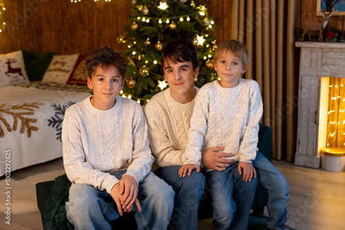 Sweet children, cute boys, brothers, playing with christmas toys on Christmas, beautifully decorated home for Christmas, cosy place photo