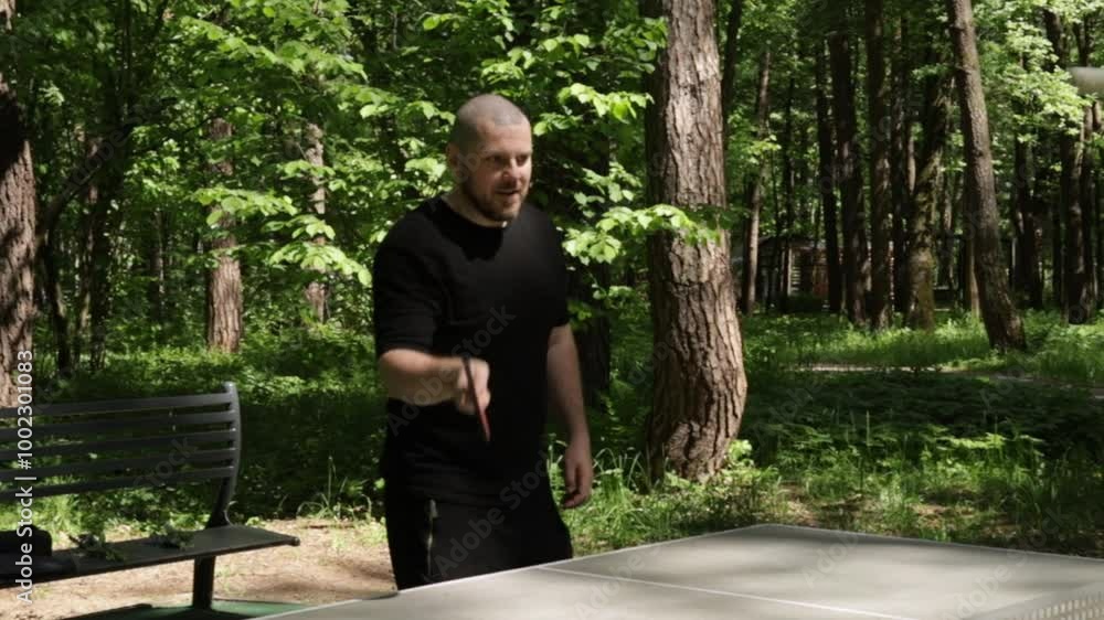 Ping pong player, enjoying an outdoor activity, playing table tennis on a court with a couple of friends. Ping pong player, enjoying an outdoor activity, playing table tennis on a court with a couple of friends.