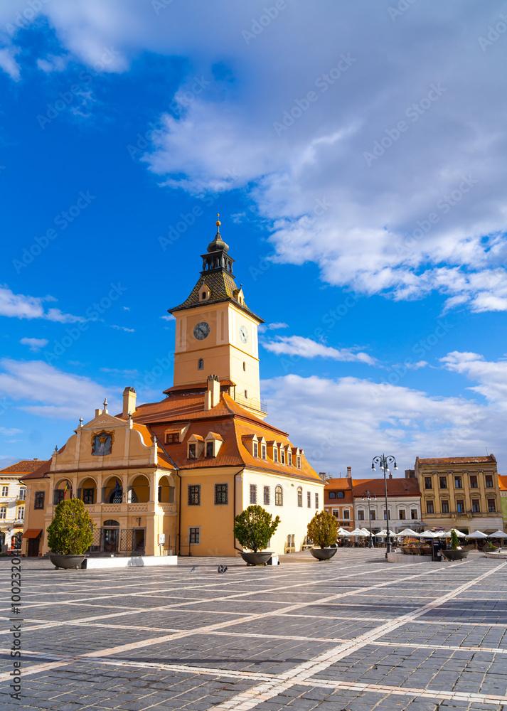 Brasov's historic architecture. Visitors admire the stunning architecture of Brasov’s famous Council Square under a bright blue sky on a sunny day. Brasov's historic architecture. Visitors admire the stunning architecture of Brasov’s famous Council Square under a bright blue sky on a sunny day.