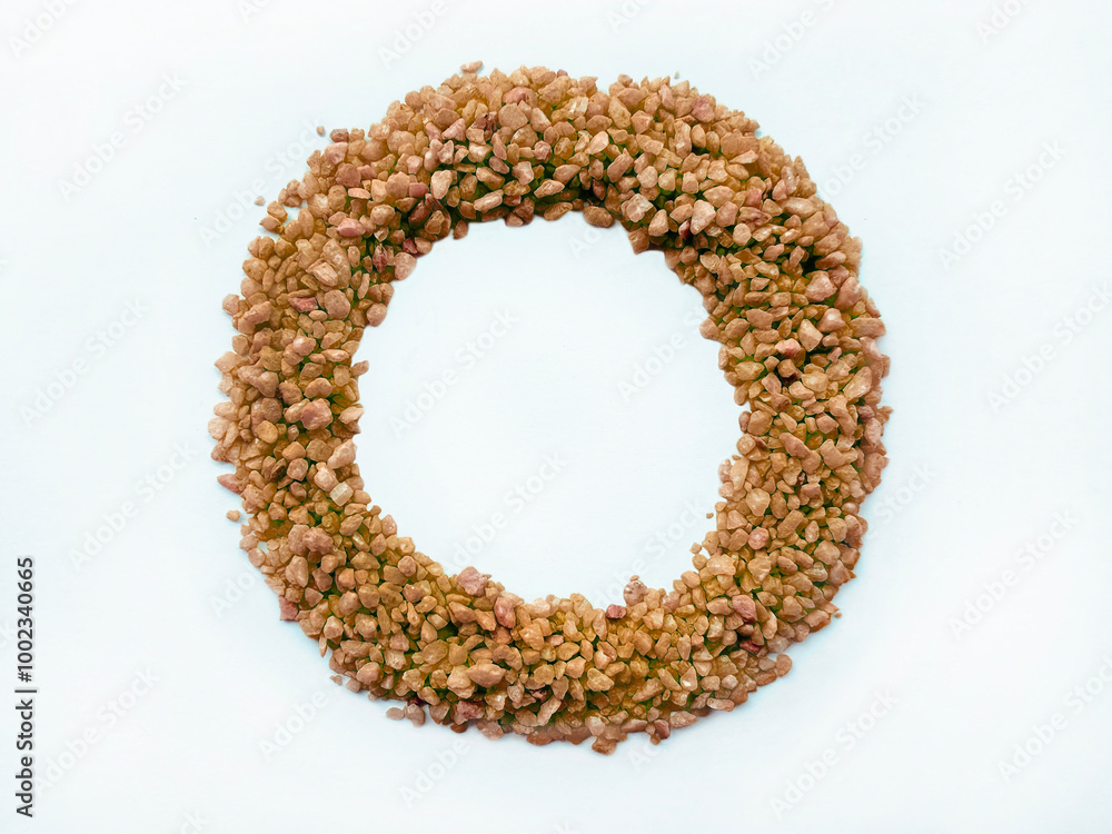 Brown sugar pebbles arranged in a circle or circular pattern to form like a ring, isolated on a white background, view from top. Brown sugar pebbles arranged in a circle or circular pattern to form like a ring, isolated on a white background, view from top.