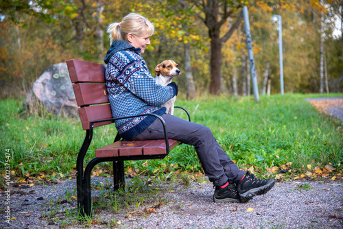 Woman sitting on the park bench with dog